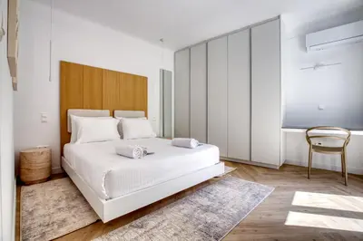a bedroom with a white bed and a chair at Whitewood Residence in Athens