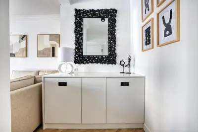 a white living room with a couch and a mirror at Whitewood Residence in Athens