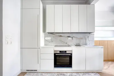 a white kitchen with white cabinets and an oven at Whitewood Residence in Athens