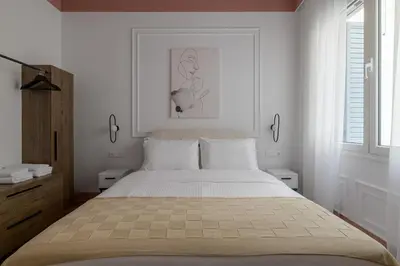 a bedroom with a large bed with white walls at Timeless Plaka Retreat in Athens