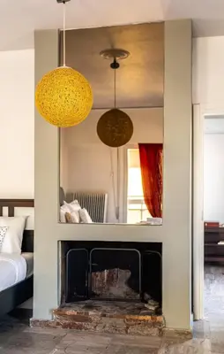 a living room with a fireplace and two hanging lights at Sunny 3bd flat,Acropolis view in Athens