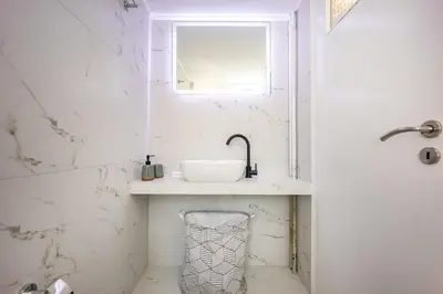 a white bathroom with a sink and a window at Sunny 3bd flat,Acropolis view in Athens
