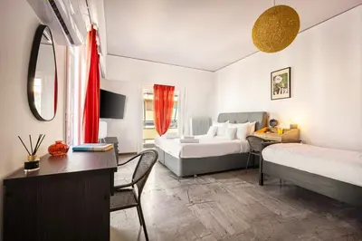 a hotel room with two beds and a desk with a desk at Sunny 3bd flat,Acropolis view in Athens