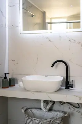 a bathroom with a white sink and a mirror at Sunny 3bd flat,Acropolis view in Athens