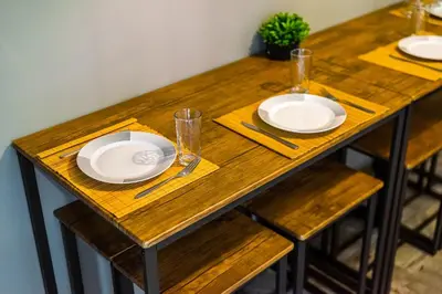 a wooden table with plates and glasses on it at Sunny 3bd flat,Acropolis view in Athens
