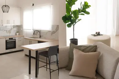 a kitchen and a living room with a couch and a table at Comfort Seaside 2BR Apartment in Palaio Faliro by UPSTREET in Athens