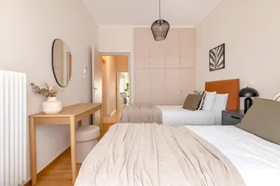 a hotel room with two beds and a desk at Comfort Seaside 2BR Apartment in Palaio Faliro by UPSTREET in Athens