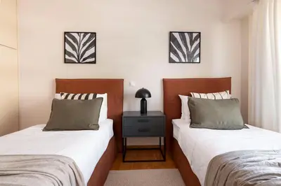 a bedroom with two beds and a night stand at Comfort Seaside 2BR Apartment in Palaio Faliro by UPSTREET in Athens
