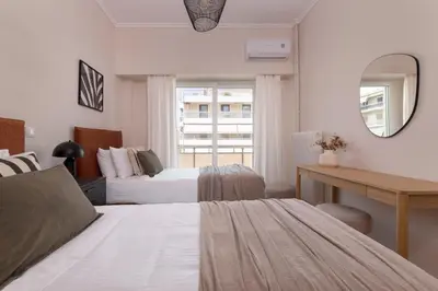 a bedroom with two beds and a desk and a mirror at Comfort Seaside 2BR Apartment in Palaio Faliro by UPSTREET in Athens