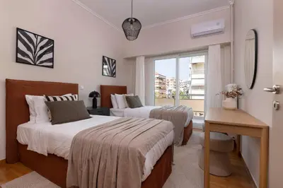 a bedroom with two beds and a window at Comfort Seaside 2BR Apartment in Palaio Faliro by UPSTREET in Athens