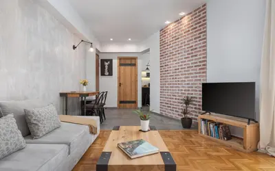 a living room with a couch and a brick wall at Acropolis Atmospheric Apartment in Athens