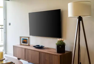 a flat screen tv on a wall with a lamp at Marbella Living Pangrati By O&O Group in Athens