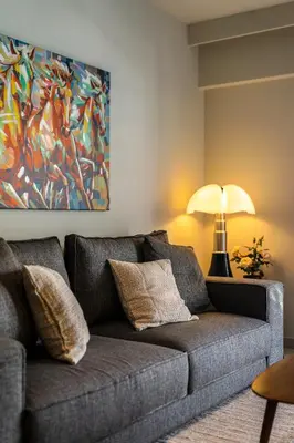 a couch in a living room with a painting on the wall at Marbella Living Pangrati By O&O Group in Athens