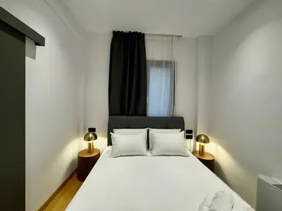 a bedroom with a white bed and two lamps at Downtown Modern Suite in Athens
