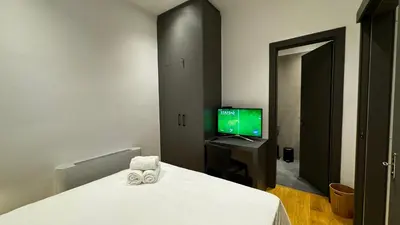 a bedroom with a bed and a television in it at Downtown Modern Suite in Athens
