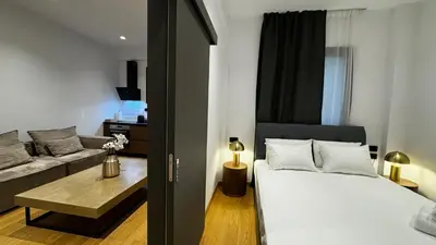a bedroom with a bed and a living room at Downtown Modern Suite in Athens