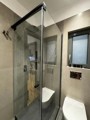 a bathroom with a shower with a toilet and a sink at Downtown Modern Suite in Athens