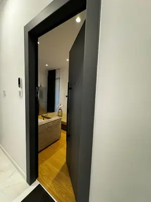 a hallway with a door to a bathroom with a sink at Downtown Modern Suite in Athens