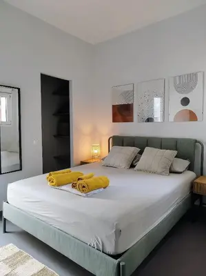a bedroom with a large bed with yellow towels on it at Spacious modern flat in Koukaki in Athens