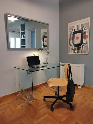 a desk with a laptop and a chair in a room at Spacious modern flat in Koukaki in Athens