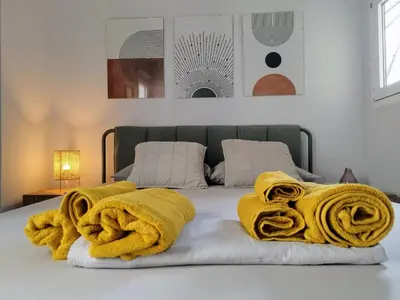a bedroom with a bed with yellow blankets on it at Spacious modern flat in Koukaki in Athens