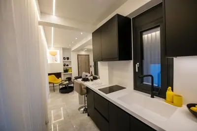 a kitchen with black cabinets and white counter tops at Nikki's Skylight Suite in Athens
