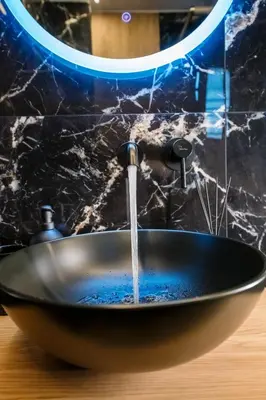 a bathroom sink with water coming out of it at Nikki's Skylight Suite in Athens