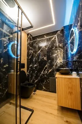 a bathroom with a black marble wall at Nikki's Skylight Suite in Athens
