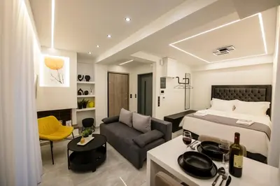 a hotel room with a bed and a couch at Nikki's Skylight Suite in Athens