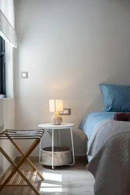 a bedroom with a bed and a table with a lamp at The One With The Lemon Tree in Athens