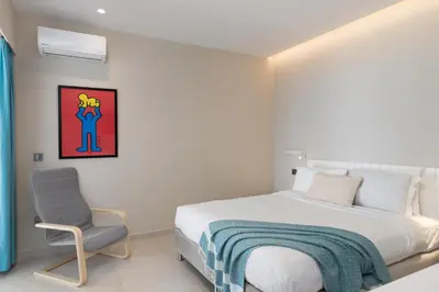 a bedroom with a bed and a chair at 2BD Luxury Sea View Penthouse in Astir Beach in Athens