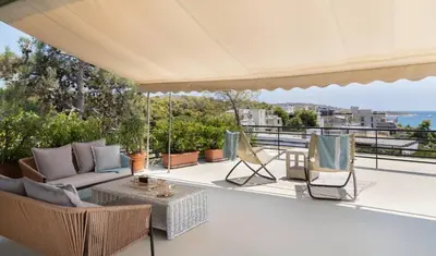 an outdoor patio with chairs and a table at 2BD Luxury Sea View Penthouse in Astir Beach in Athens