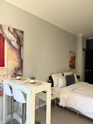 a bedroom with a bed and a table and a bed at Aiolou 68str rooms & apartments in Athens