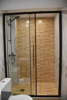 a shower with a glass door in a bathroom at Aiolou 68str rooms & apartments in Athens