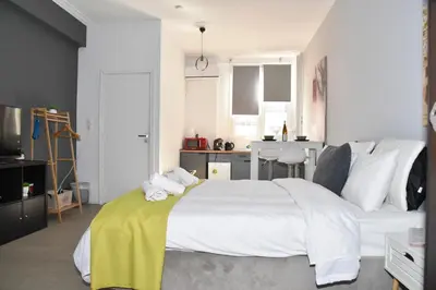 a bedroom with a large bed with a yellow blanket on it at Aiolou 68str rooms & apartments in Athens