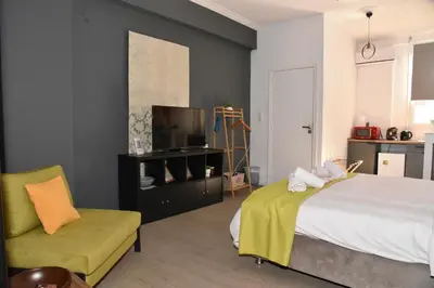 a bedroom with a bed and a couch and a television at Aiolou 68str rooms & apartments in Athens