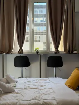 a bed in a bedroom with two chairs in front of a window at Aiolou street rooms & apartments# in Athens