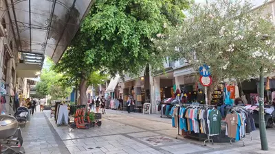 a street with a group of shops on a sidewalk at Aiolou street rooms & apartments# in Athens