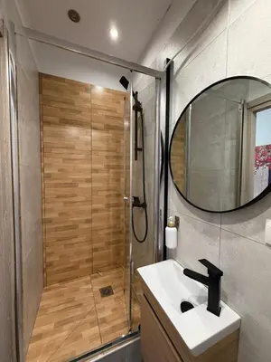 a bathroom with a shower and a sink and a mirror at Aiolou street rooms & apartments# in Athens