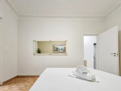 a white room with a bed and a mirror at Casa Divas City Stay in Athens