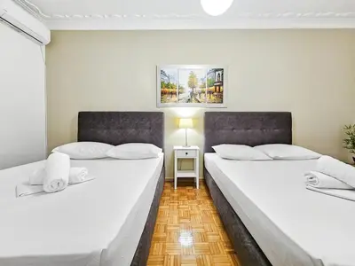 two beds in a room with white walls at Casa Divas City Stay in Athens