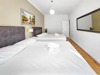 a large room with two beds and a mirror at Casa Divas City Stay in Athens