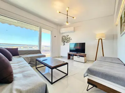 a living room with a couch and a tv at Acropolis Vista View in Athens