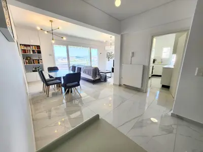 a dining room and living room with a table and chairs at Acropolis Vista View in Athens