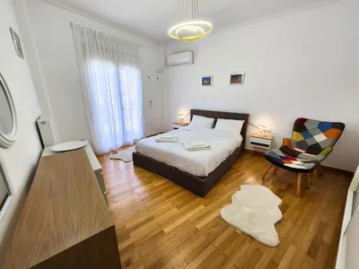 a bedroom with a bed and a chair at Acropolis Vista View in Athens