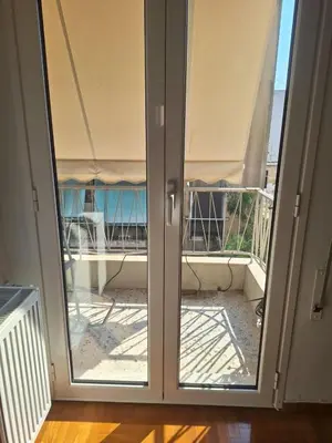 a sliding glass door with a view of a balcony at Cozy renovated flat with balcony in Athens