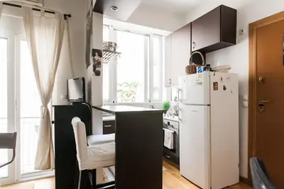a kitchen with a white refrigerator and a window at Cozy renovated flat with balcony in Athens