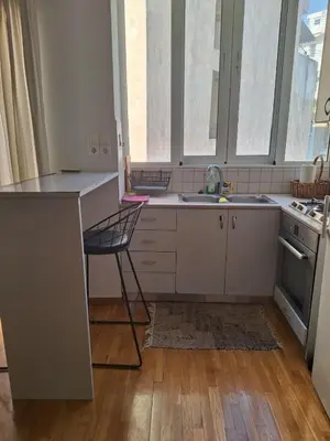 a kitchen with a counter and a chair in it at Cozy renovated flat with balcony in Athens