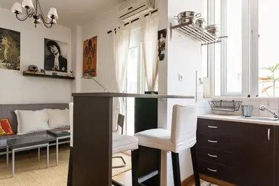 a kitchen with a counter and a living room at Cozy renovated flat with balcony in Athens