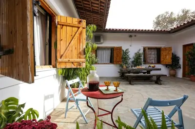 a patio with chairs and a table with drinks on it at Marousa's Country House 12 minutes from Athens Airport in Koropíon